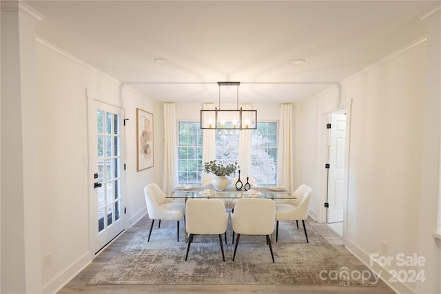 dining room featuring an inviting chandelier, ornamental molding, and wood-type flooring