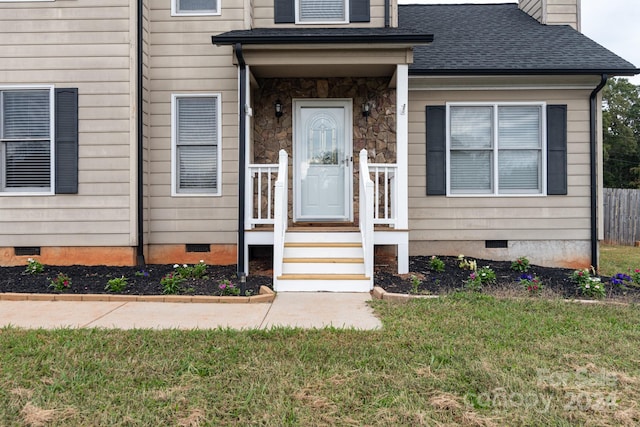 property entrance with a lawn