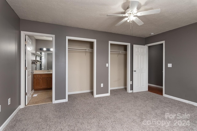 unfurnished bedroom with a textured ceiling, ensuite bathroom, and ceiling fan