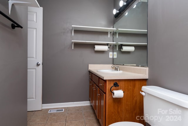 bathroom featuring toilet, vanity, and tile patterned floors