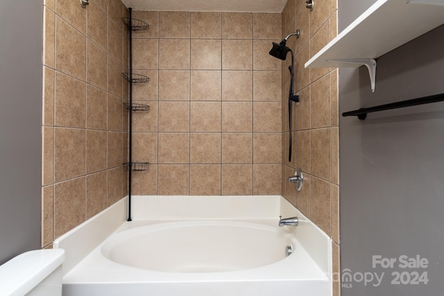 bathroom with toilet and tiled shower / bath combo