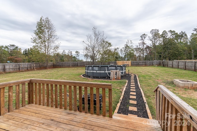 wooden deck featuring a yard and a fenced in pool