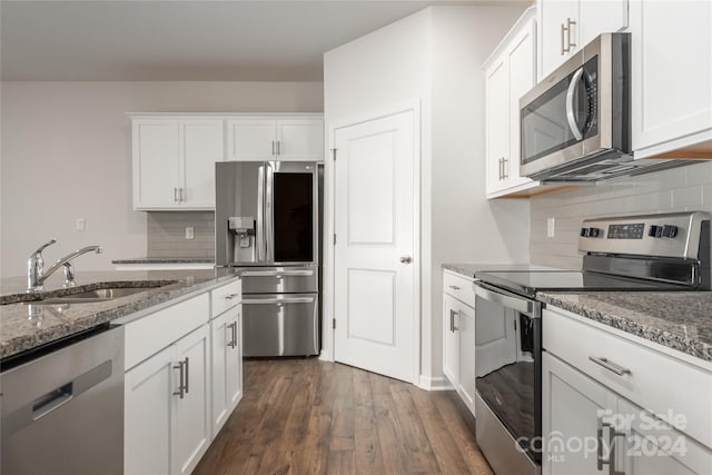 kitchen featuring stone counters, white cabinetry, stainless steel appliances, and sink