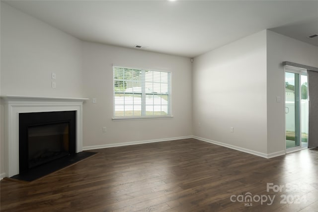 unfurnished living room with dark wood-type flooring