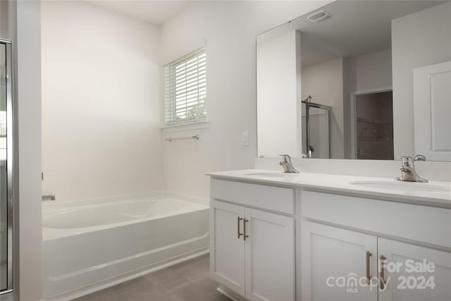 bathroom with vanity and shower with separate bathtub