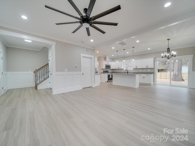 unfurnished living room with ceiling fan with notable chandelier, light wood-type flooring, crown molding, and sink