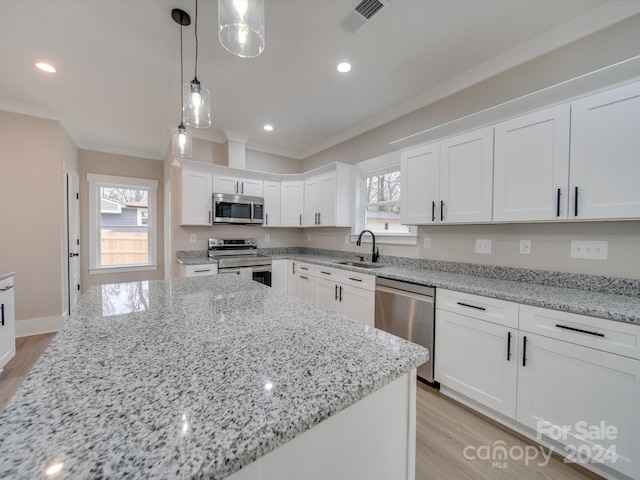 kitchen featuring white cabinets, stainless steel appliances, a healthy amount of sunlight, and sink