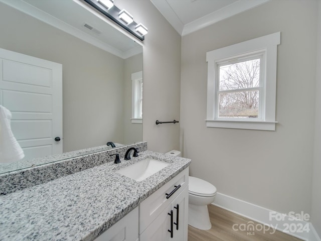 bathroom featuring wood-type flooring, vanity, toilet, and ornamental molding