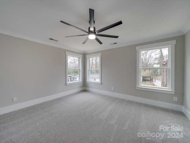 carpeted empty room with crown molding, plenty of natural light, and ceiling fan