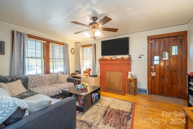 living room with hardwood / wood-style flooring, a fireplace, and ceiling fan