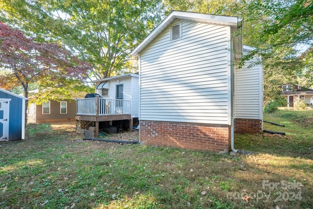 view of property exterior with a storage shed, a deck, and a yard