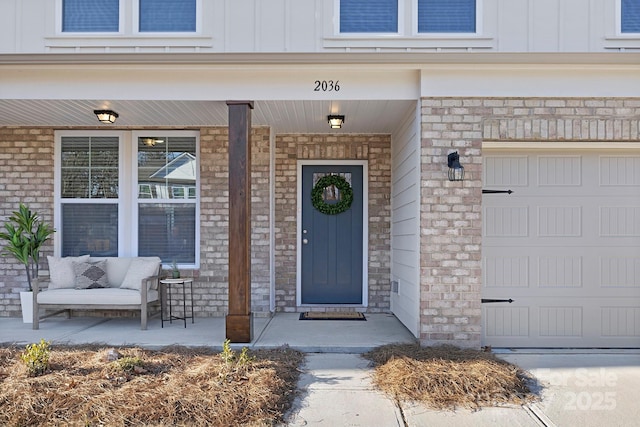 view of exterior entry with a garage, covered porch, and board and batten siding