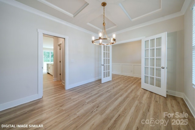 unfurnished dining area with light wood-style floors, french doors, coffered ceiling, and ornamental molding