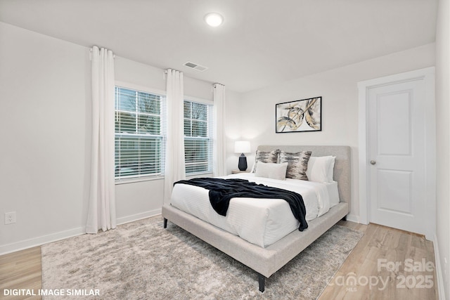 bedroom with light wood-style floors, baseboards, and visible vents