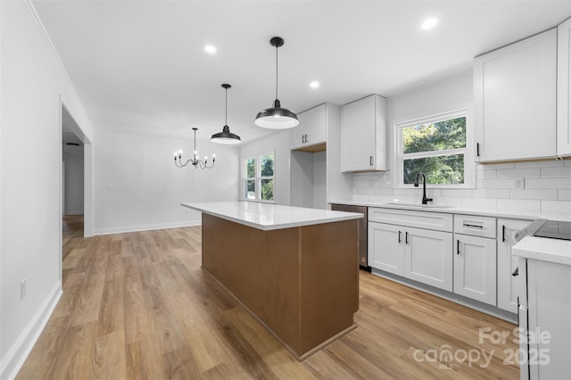 kitchen featuring tasteful backsplash, white cabinets, dishwasher, and a sink