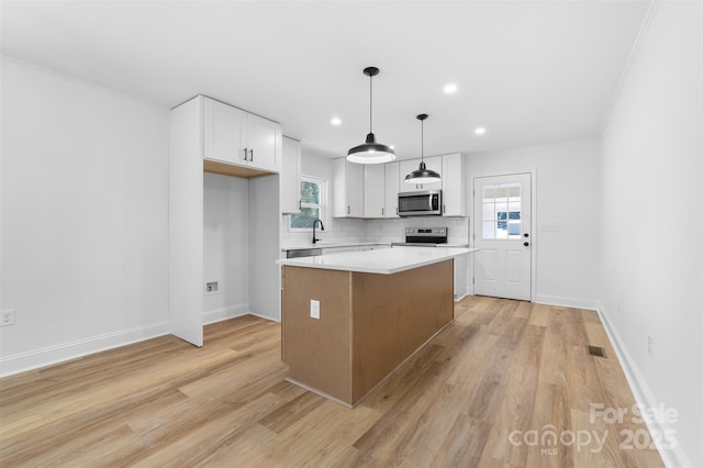 kitchen with visible vents, backsplash, a center island, white cabinets, and stainless steel appliances