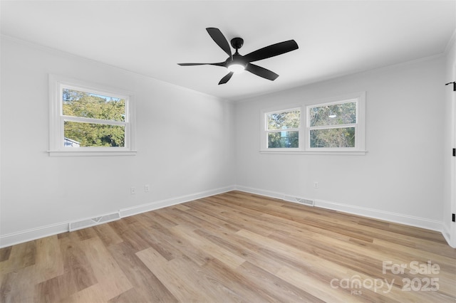 unfurnished room with a healthy amount of sunlight, light wood-type flooring, and baseboards