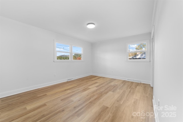 spare room with visible vents, baseboards, and light wood-style flooring