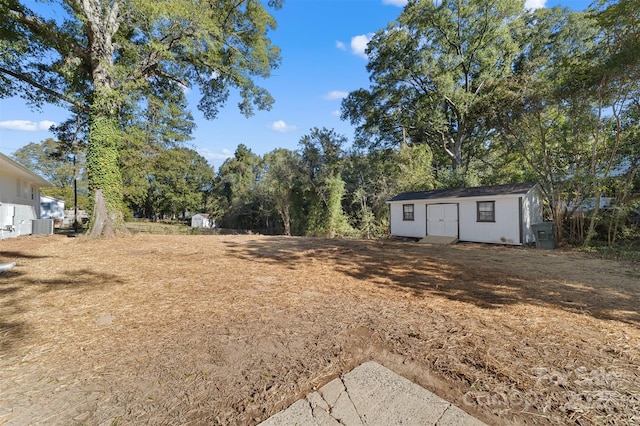 view of yard with a storage shed, central air condition unit, and an outdoor structure