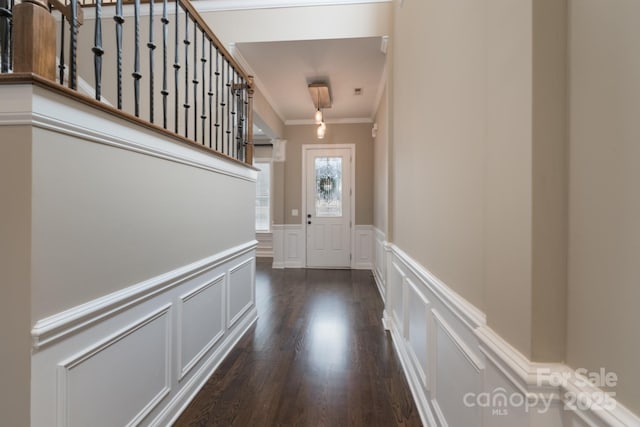 doorway to outside featuring crown molding and dark hardwood / wood-style flooring