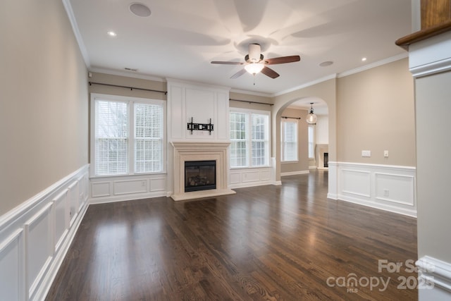 unfurnished living room with dark wood-type flooring, ceiling fan, and crown molding