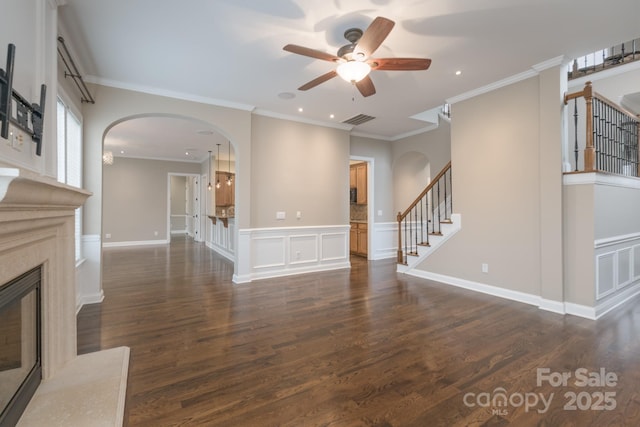 unfurnished living room featuring crown molding, dark wood-type flooring, and a high end fireplace