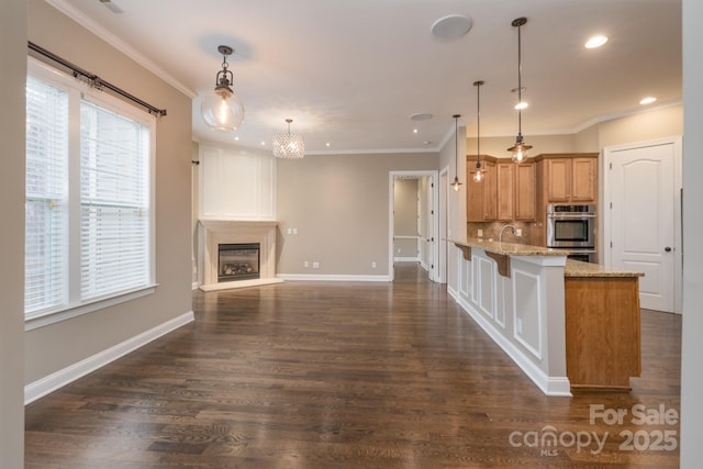 kitchen with a breakfast bar, a fireplace, decorative light fixtures, kitchen peninsula, and light stone countertops