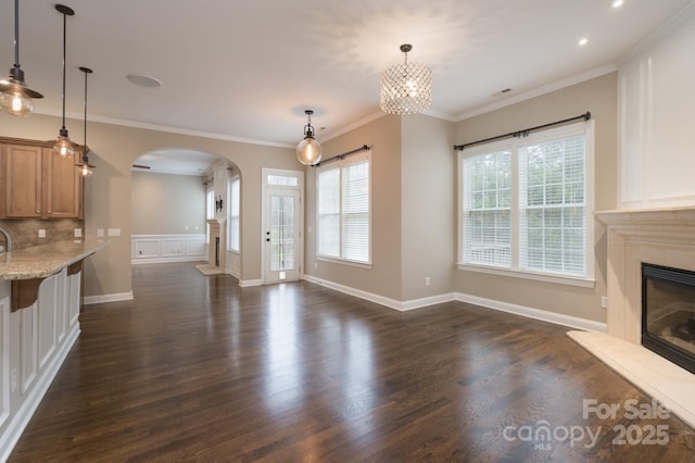 unfurnished living room featuring crown molding and dark hardwood / wood-style floors