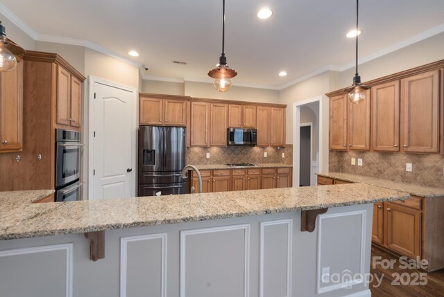 kitchen with a breakfast bar, appliances with stainless steel finishes, light stone counters, decorative light fixtures, and kitchen peninsula