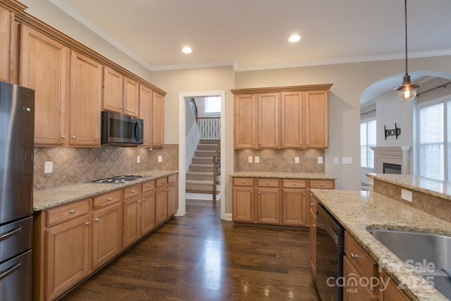 kitchen featuring stainless steel appliances, light stone countertops, dark wood-type flooring, and decorative light fixtures