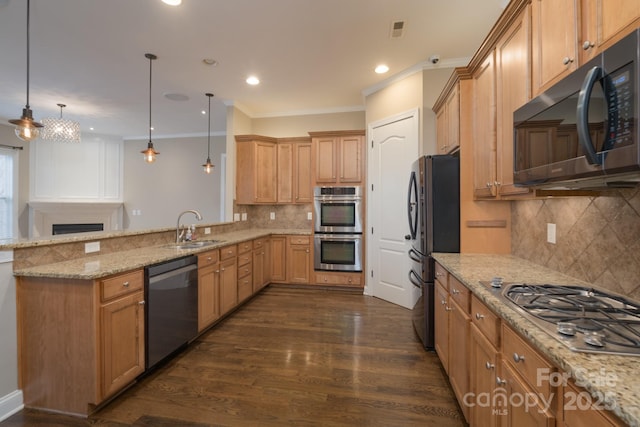 kitchen featuring sink, decorative light fixtures, appliances with stainless steel finishes, kitchen peninsula, and light stone countertops