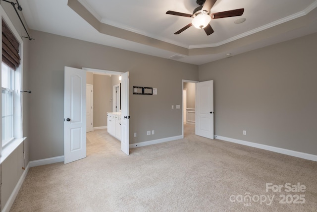 unfurnished bedroom featuring a tray ceiling, ornamental molding, and light colored carpet