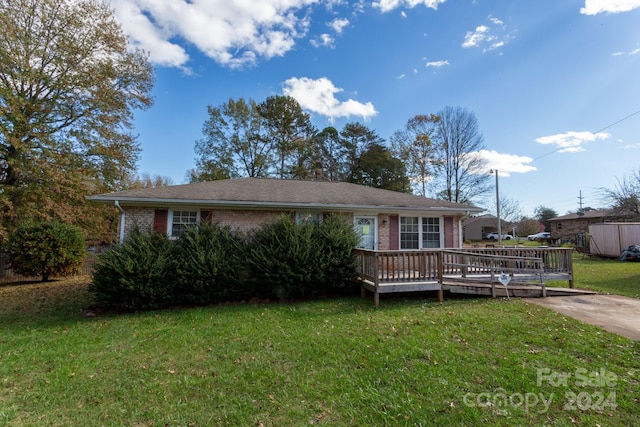 ranch-style home featuring a front lawn and a deck