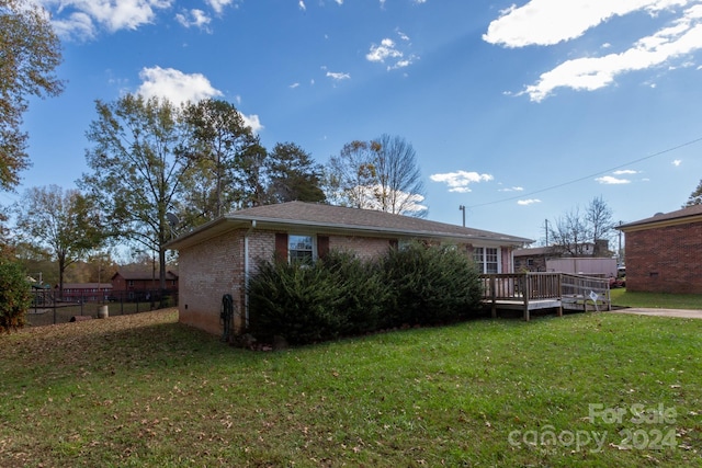 rear view of property with a lawn and a deck