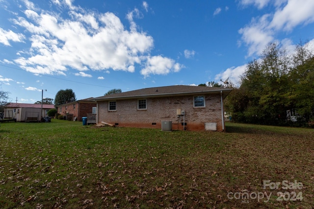 back of house with a yard and cooling unit