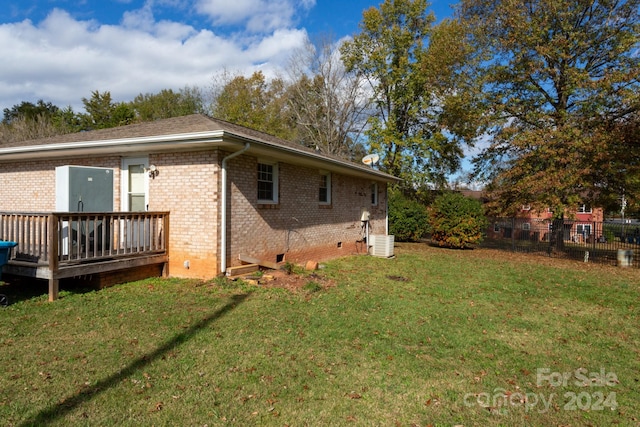 view of side of home with central air condition unit, a wooden deck, and a lawn