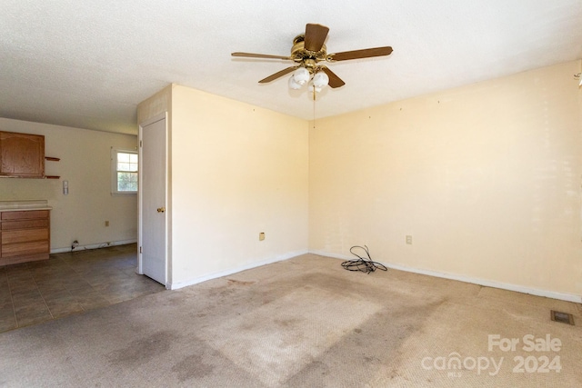 carpeted empty room featuring a textured ceiling and ceiling fan