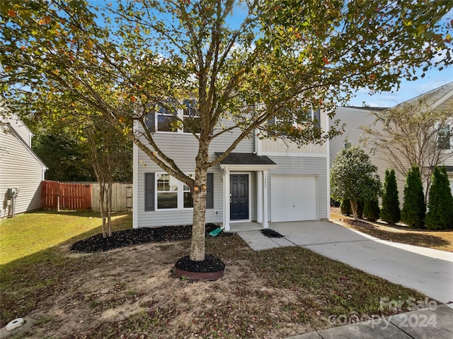 view of front of property with a front yard and a garage