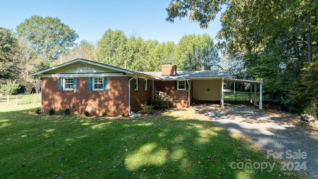 view of front of property featuring a front lawn and a carport