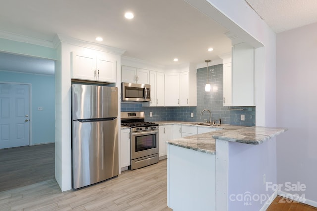 kitchen with appliances with stainless steel finishes, kitchen peninsula, white cabinets, and light hardwood / wood-style floors