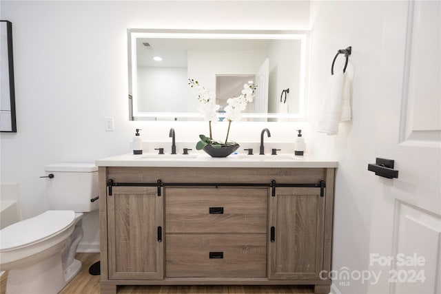 bathroom featuring vanity, hardwood / wood-style floors, and toilet