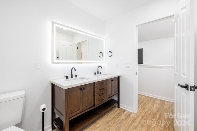 bathroom featuring vanity, hardwood / wood-style floors, and toilet