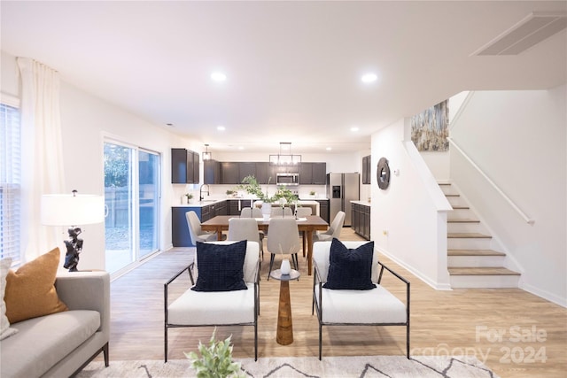 living room with light hardwood / wood-style flooring and sink