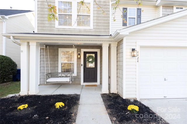 property entrance featuring a porch and a garage