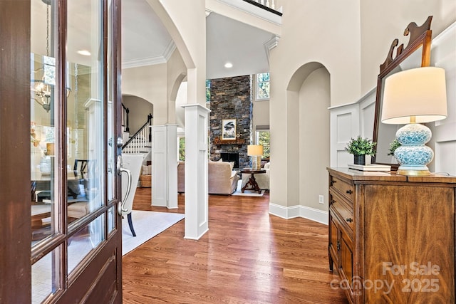 entryway featuring a fireplace, dark wood-type flooring, and ornamental molding