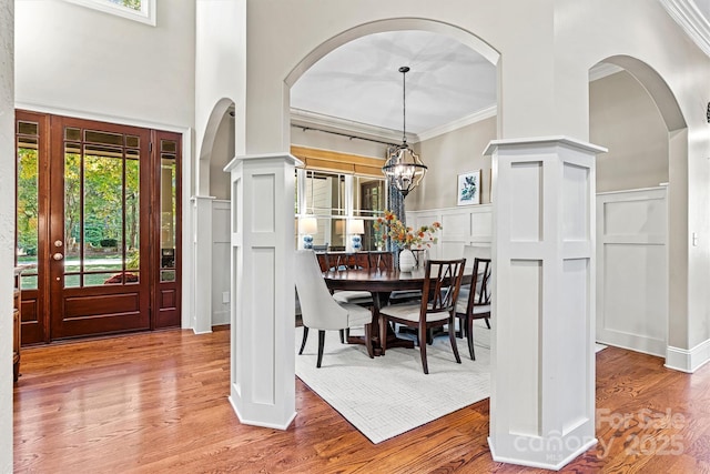 dining space with hardwood / wood-style floors, a notable chandelier, and ornamental molding