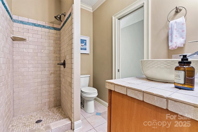 bathroom featuring tile patterned flooring, tiled shower, toilet, and crown molding