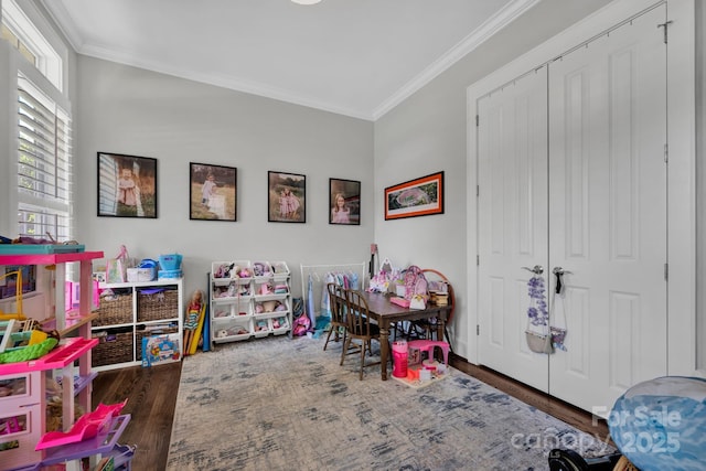 game room featuring ornamental molding and dark hardwood / wood-style flooring