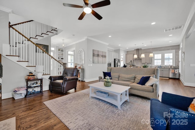 living room featuring hardwood / wood-style flooring, crown molding, sink, and ceiling fan