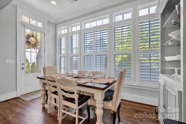 dining area with ornamental molding and dark hardwood / wood-style flooring